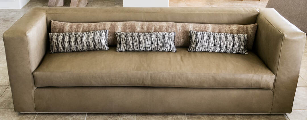 Leather sofa upholstered for private client in La Quinta and pillows in a horse like fiber finish that is faux and customers own material